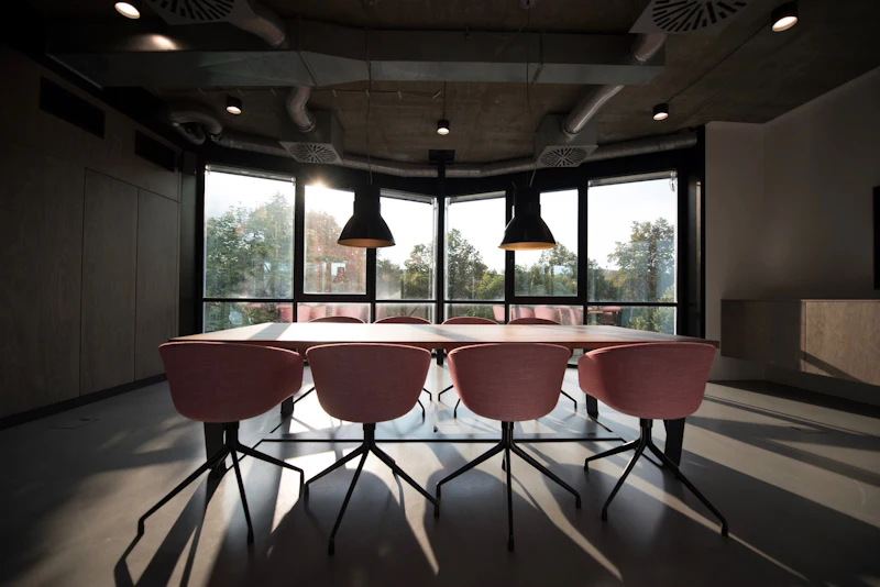 A meeting table with specified chairs set out in a glazed room off the main floor